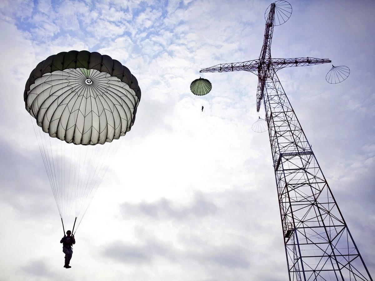 A soldier is dropped from a 250-foot tower under a T-10 parachute during Airborne School at Fort Benning, August 2013 (U.S. Army photo).